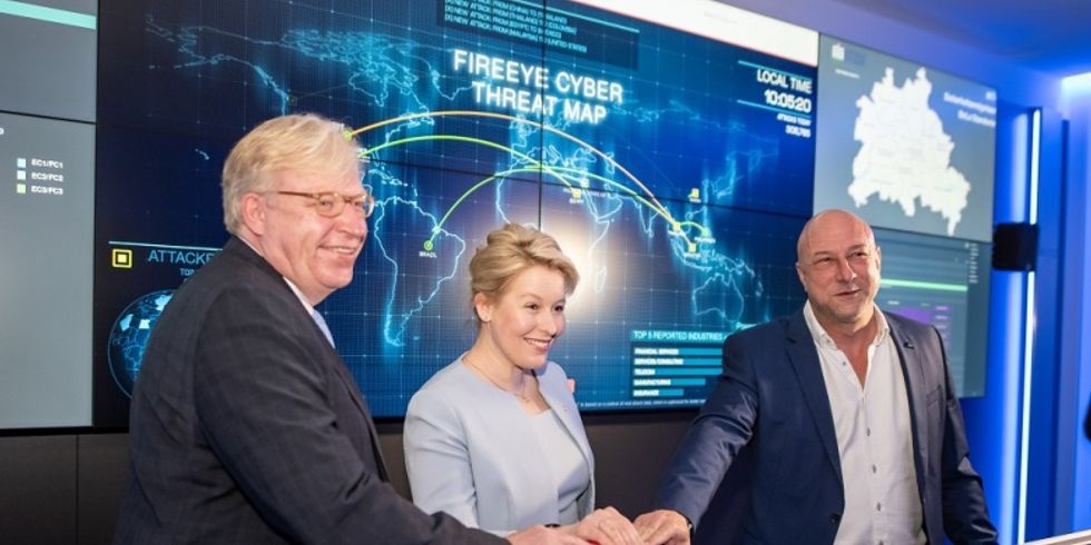 Franziska Giffey (in der Mitte), Dr. Ralf Kleindiek (links aussen) und Marc Böttcher (rechts) drücken einen großen roten Startbutton vor einer großen Monitorwand