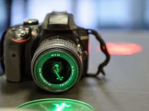 Eine DSLR Kamera auf einem Tisch angestrahlt von grünem licht