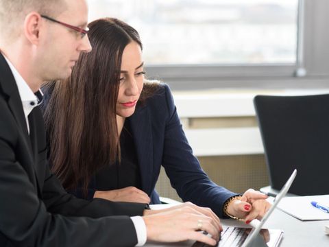 2 Mitarbeitende an einem Laptop
