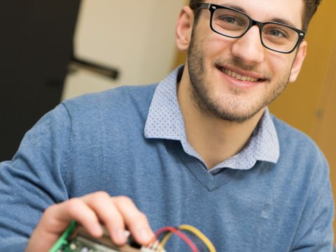 junger Mann hält Platine