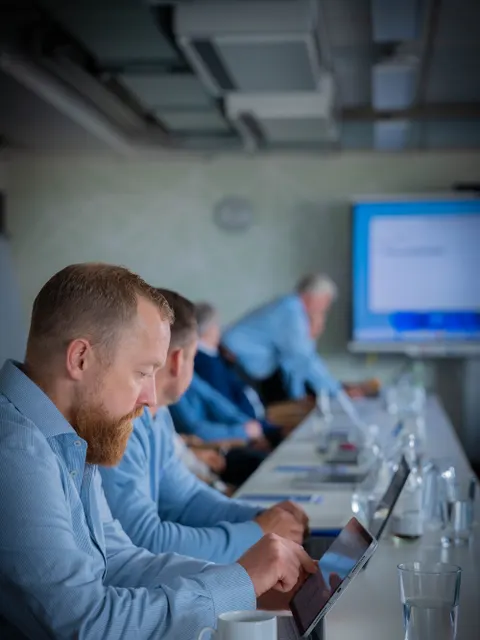 Menschen sitzen nebeneinander an einem Tisch und arbeiten am Rechner