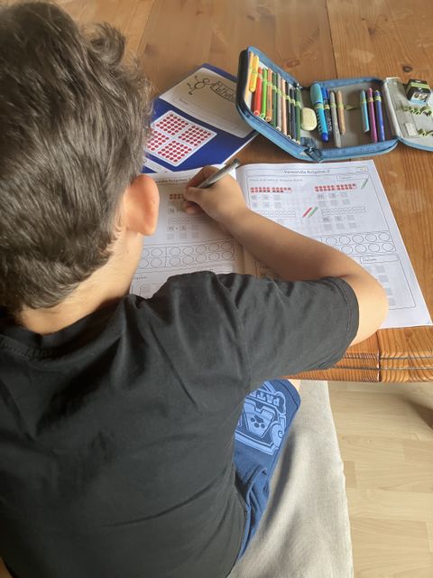 Schüler arbeitet mit dem Matheheft am Tisch