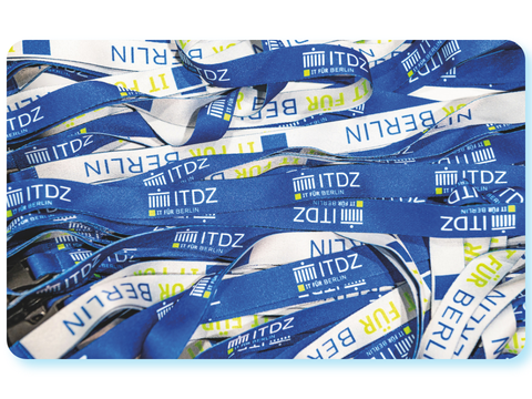 Mehrere blaue und weiße Schlüsselbänder mit ITDZ-Berlin-Logo liegen übereinander.
