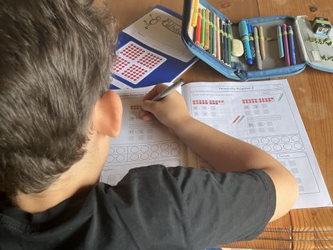 Schüler arbeitet mit dem Matheheft am Tisch