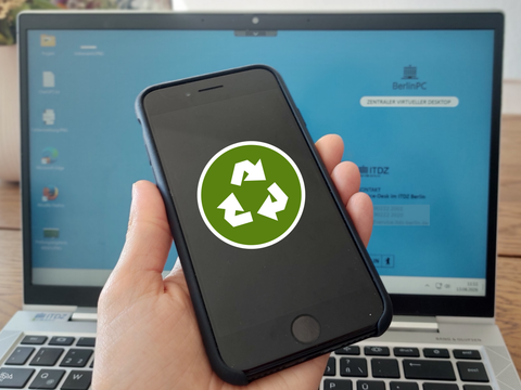Handy in einer Hand, auf dem Display ist ein Recycle-Symbol zu sehen