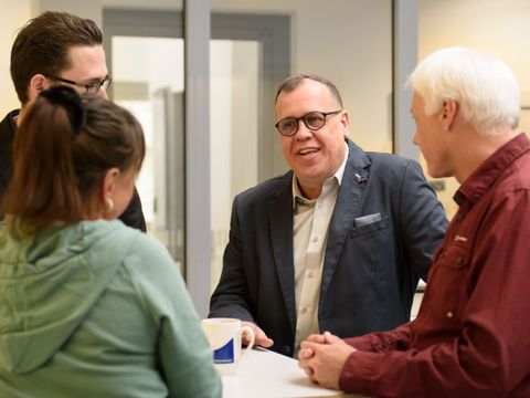 Vier Angestellte, die sich unterhalten
