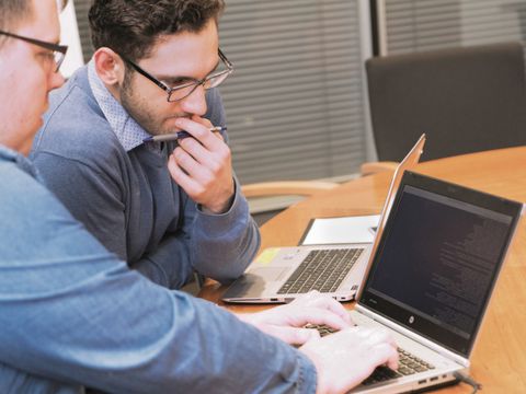 zwei Werkstudenten an einem Laptop