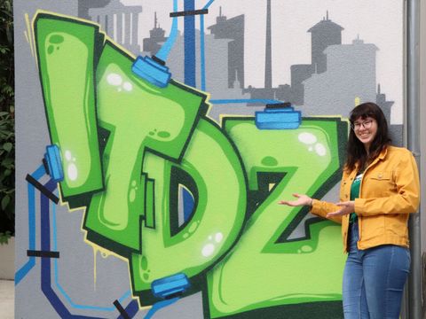 Entertechnik-Frau vor ITDZ Graffiti