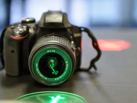 Eine DSLR Kamera auf einem Tisch angestrahlt von grünem licht
