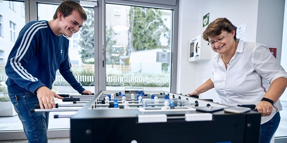 Mitarbeitende spielen am Kickertisch