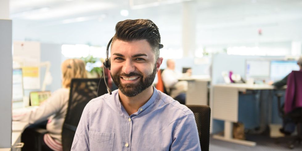 Person mit Headset lacht freundlich in die Kamera