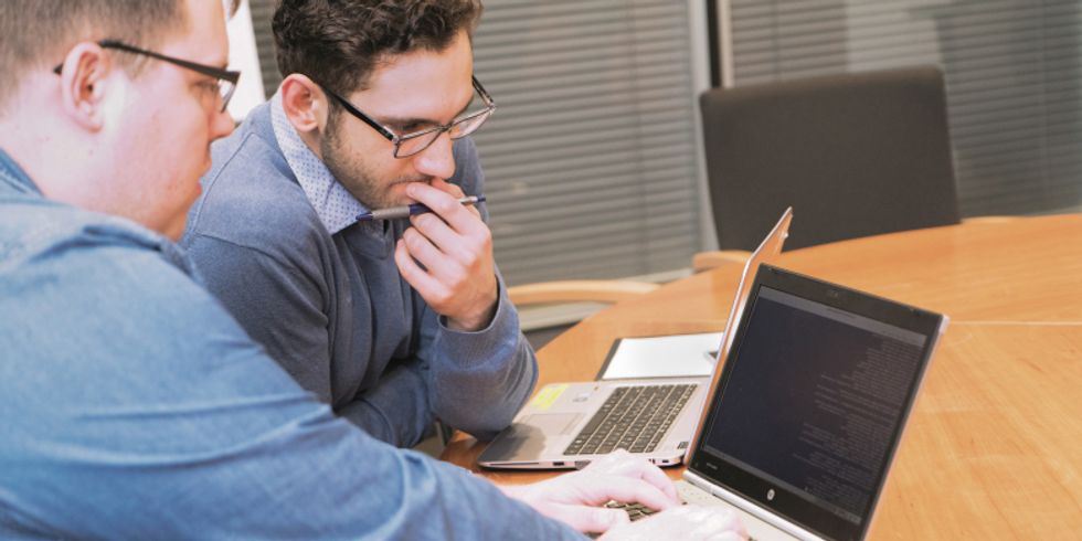 zwei Werkstudenten an einem Laptop