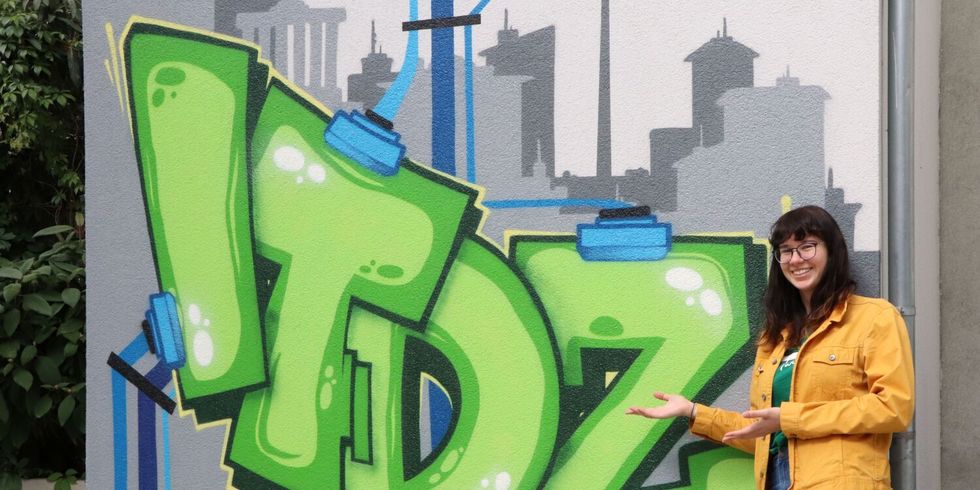 Entertechnik-Frau vor ITDZ Graffiti