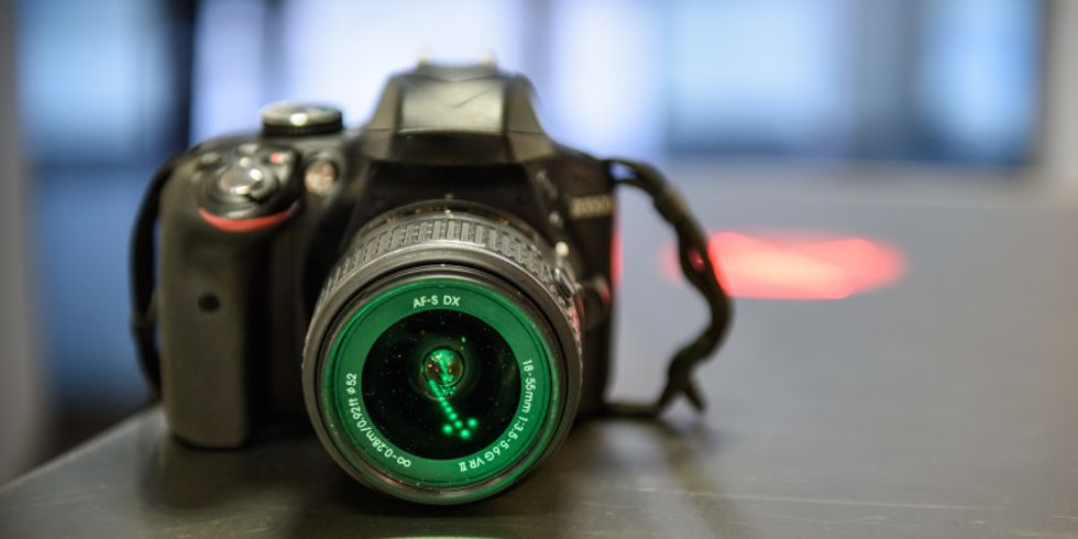 Eine DSLR Kamera auf einem Tisch angestrahlt von grünem licht