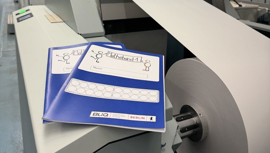 Mathebücher liegen auf einer Maschine im Druckzentrum