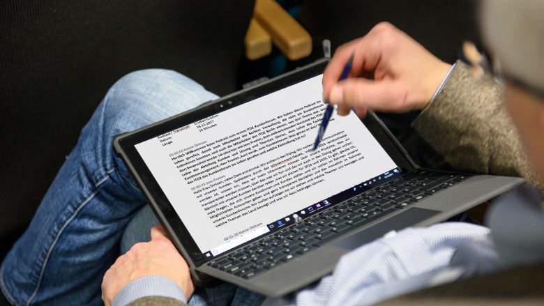 Ein geöffneter Laptop auf dem Schoß einer Person