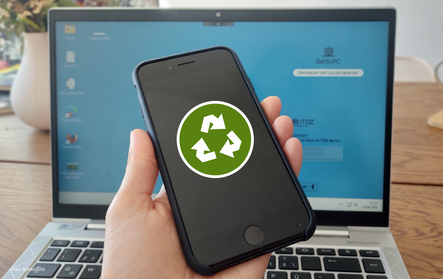 Handy in einer Hand, auf dem Display ist ein Recycle-Symbol zu sehen