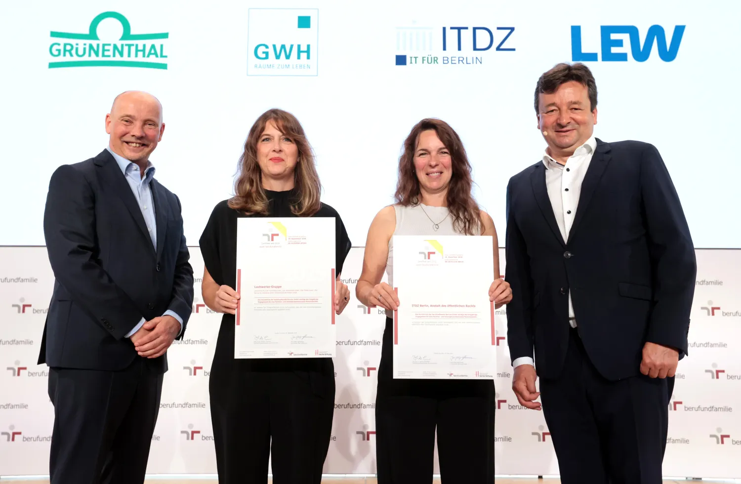 Zwei Fraun halten Zertifikat, links und rechts von ihnen steht jeweils ein Mann
