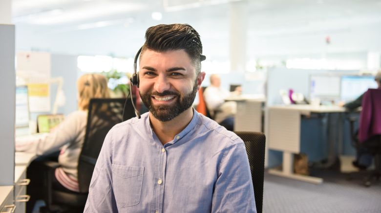 Person mit Head Set lacht freundlich in die Kamera