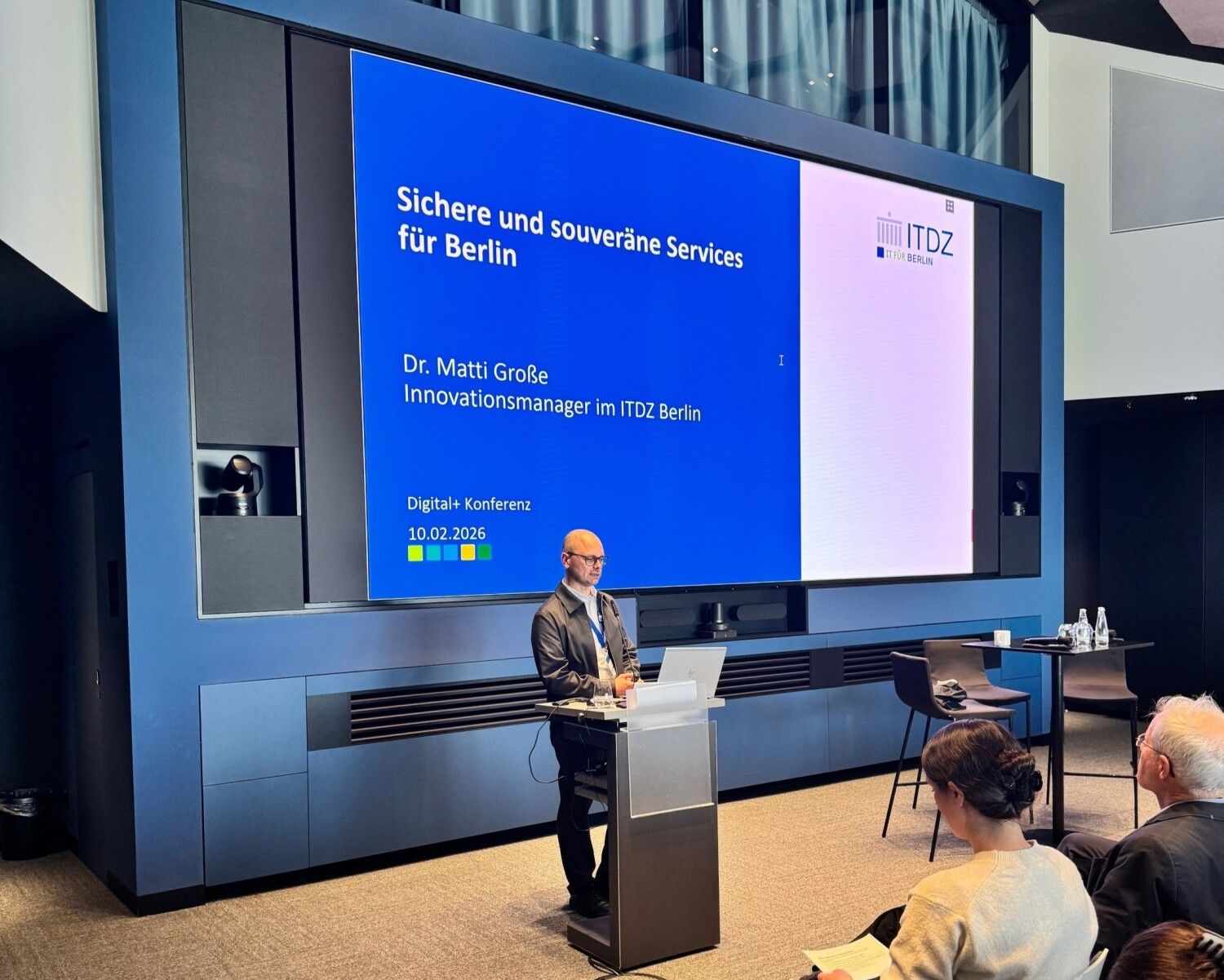 Mann steht am Rednerpult und präsentiert.