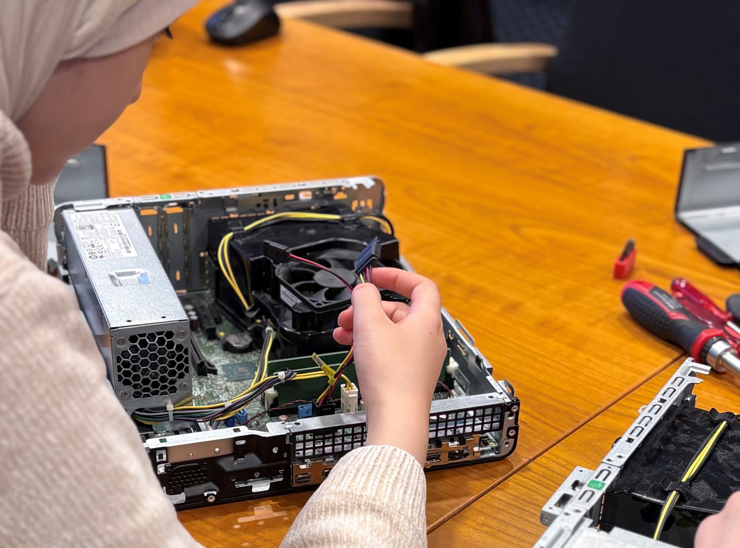 Mädchen schraubt an offenem Rechner