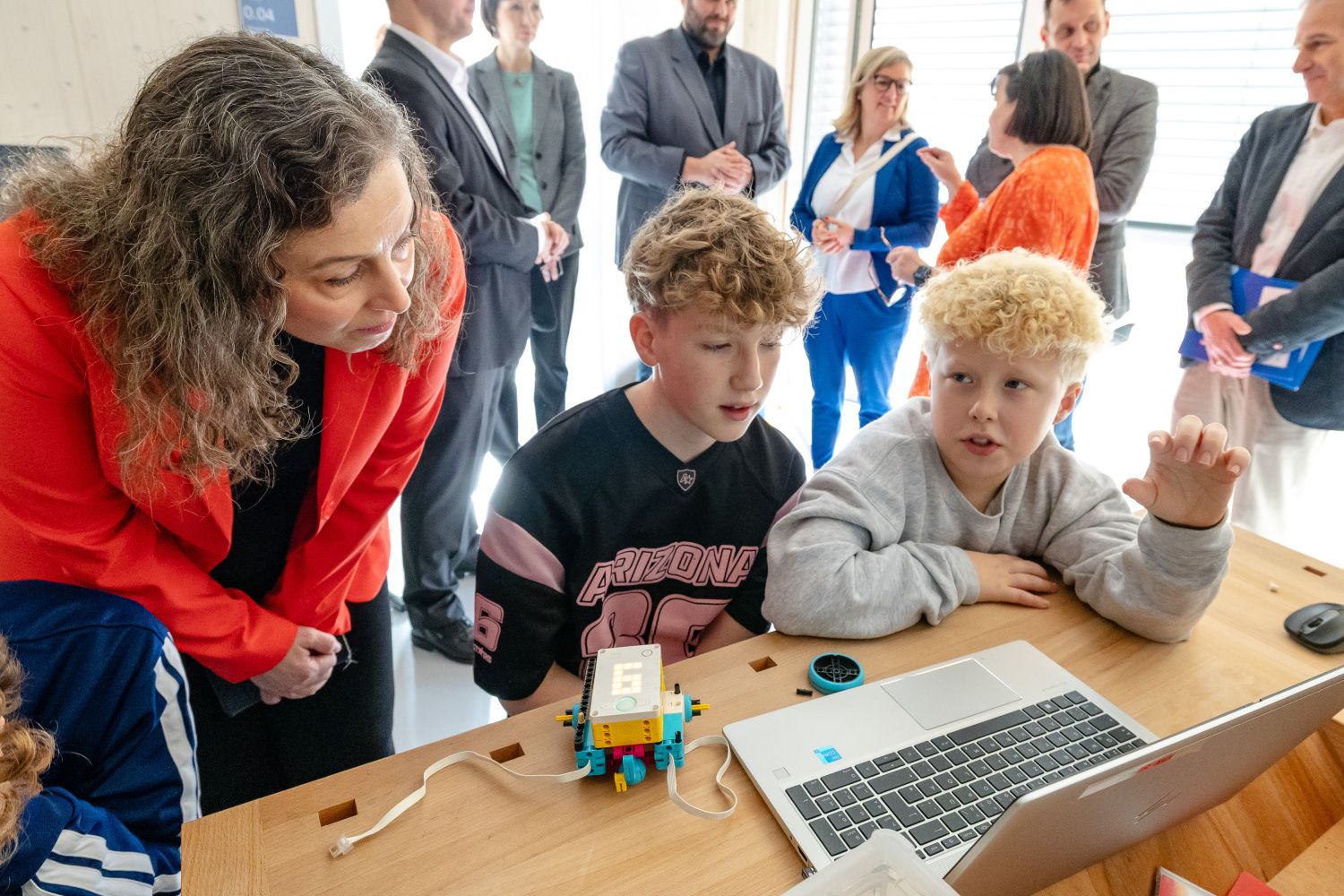 Dr. Maria Borelli schaut Schülern bei der arbeit am Laptop zu