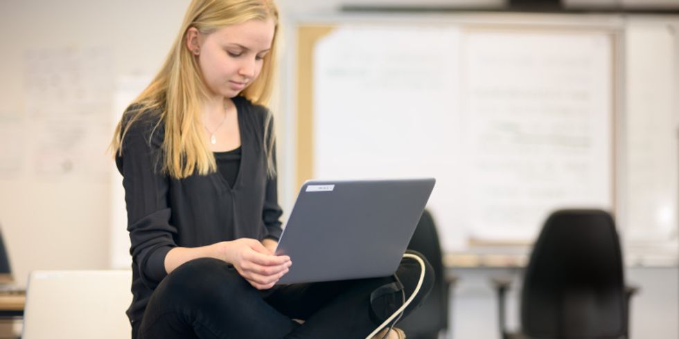 Praktikantin mit einem Laptop auf dem Schoß