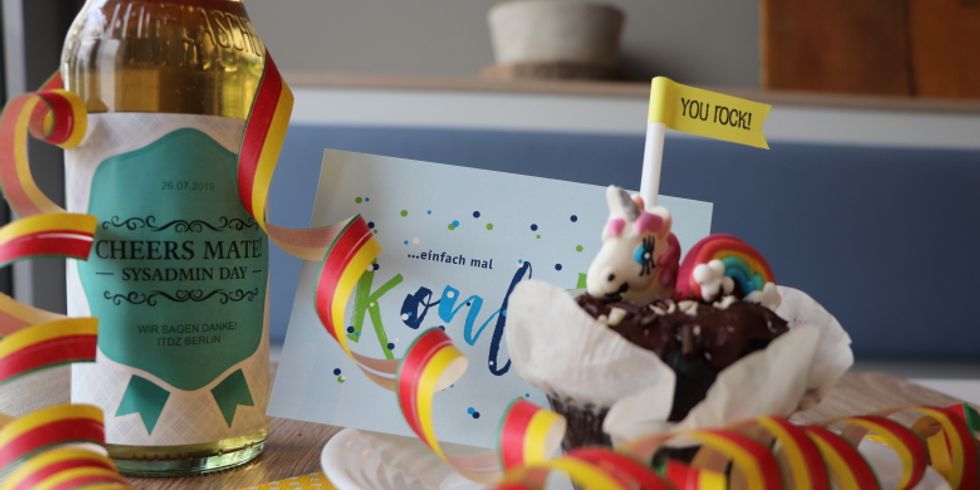 Ein Muffin, Luftschlangen und ein Getränk im Bild.