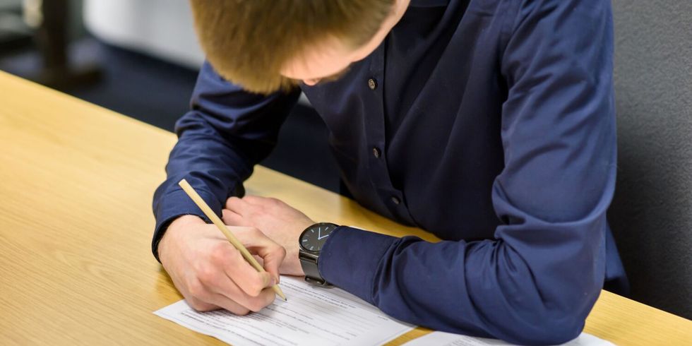 Ein Mitarbeiter notiert etwas auf einem Blatt Papier.