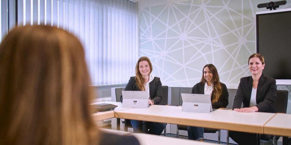 Drei Frauen hören einer Frau zu.