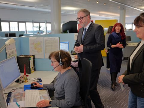 CDO Matthias Hundt steht hinter einer Mitarbeiterin im telefonischen Servicecenter der 115