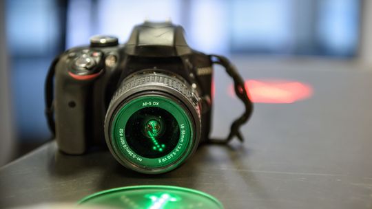 Eine DSLR Kamera auf einem Tisch angestrahlt von grünem licht