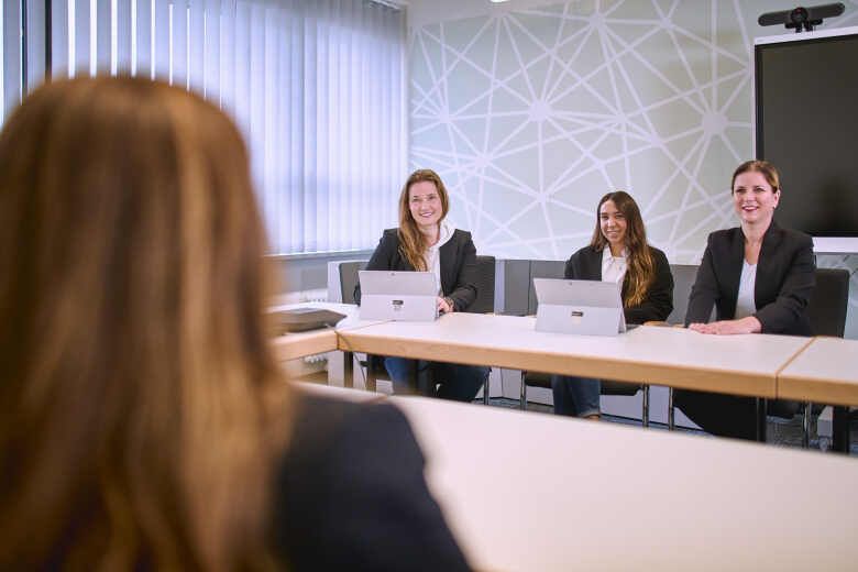 Drei Frauen hören einer Frau zu.