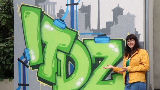 Entertechnik-Frau vor ITDZ Graffiti
