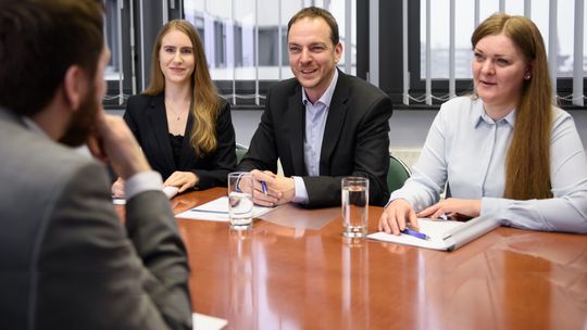 Drei Mitarbeitende sitzen gegenüber einem Bewerber für das ITDZ-Berlin