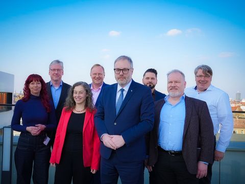 CDO und Managementrunde lächeln in die Kamera.